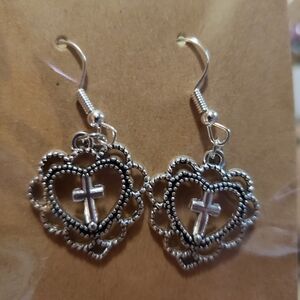 Silver and black heart with cross in the middle.